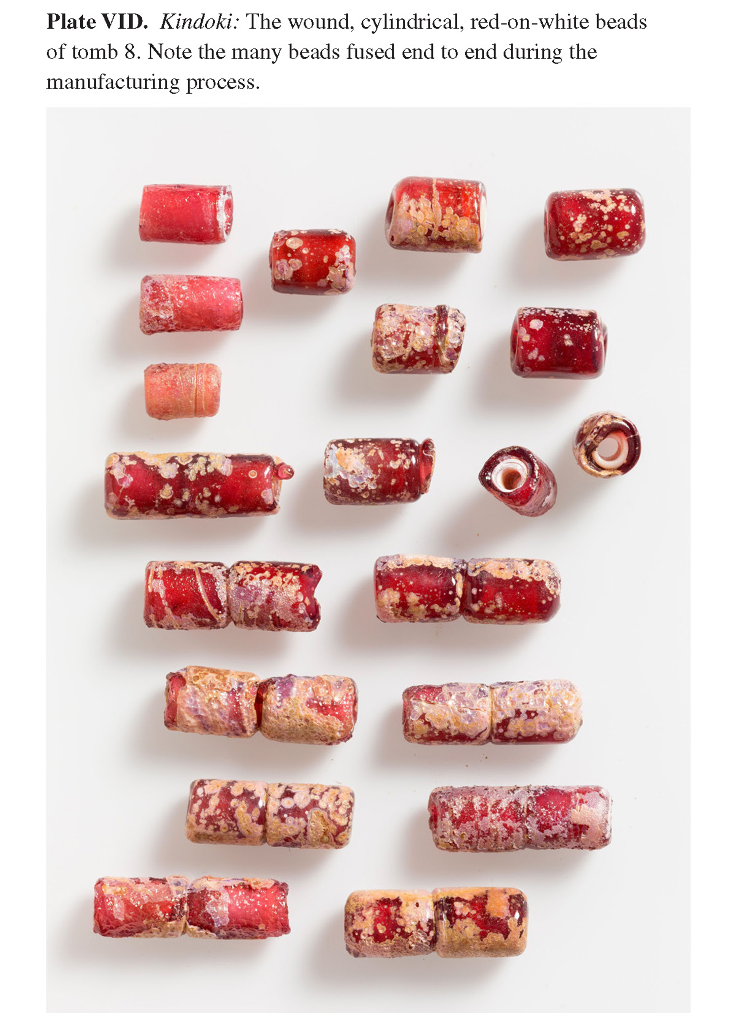 Plate VID Kindoki: The wound, cylindrical, red-on-white beads of tomb 8. Note the many beads fused end to end during the manufacturing process.