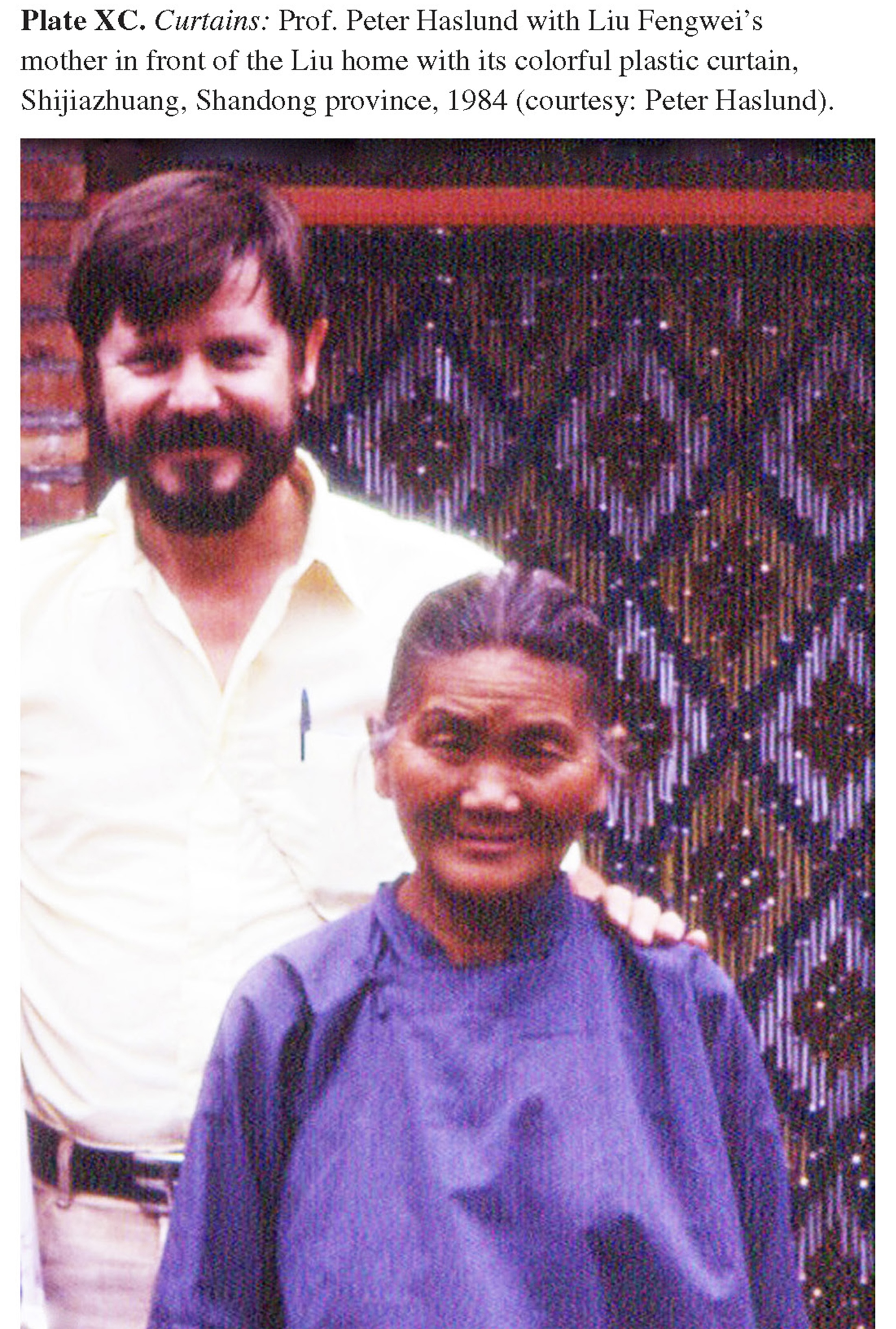 Plate XC Curtains: Prof. Peter Haslund with Liu Fengwei’s mother in front of the Liu home with its colorful plastic curtain, Shijiazhuang, Shandong province, 1984 (courtesy: Peter Haslund).