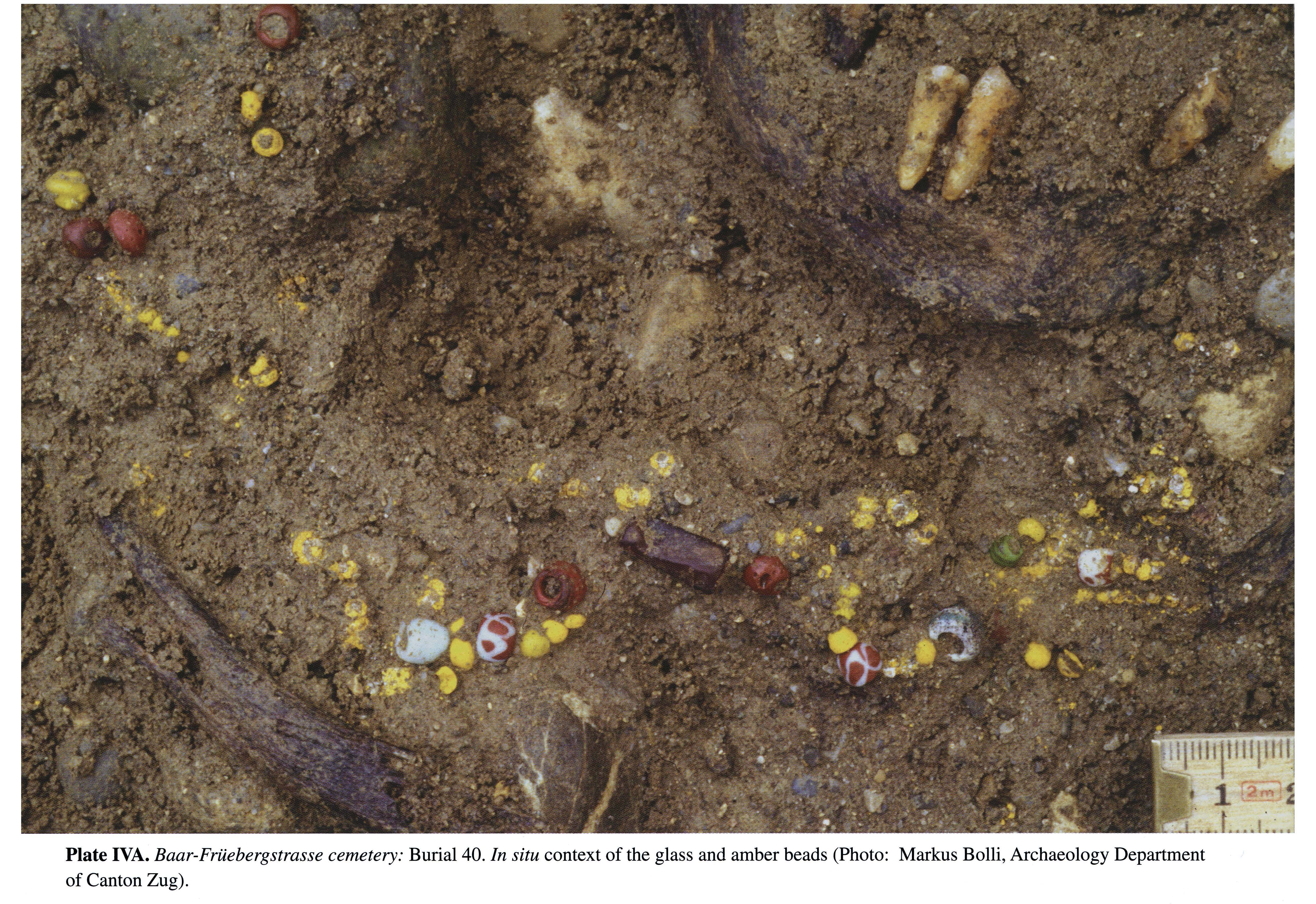 Plate IVA Baar-Früebergstrasse cemetery: Burial 40. In situ context of the glass and amber beads (Photo: Markus Bolli, Archaeology Department of Canton Zug).