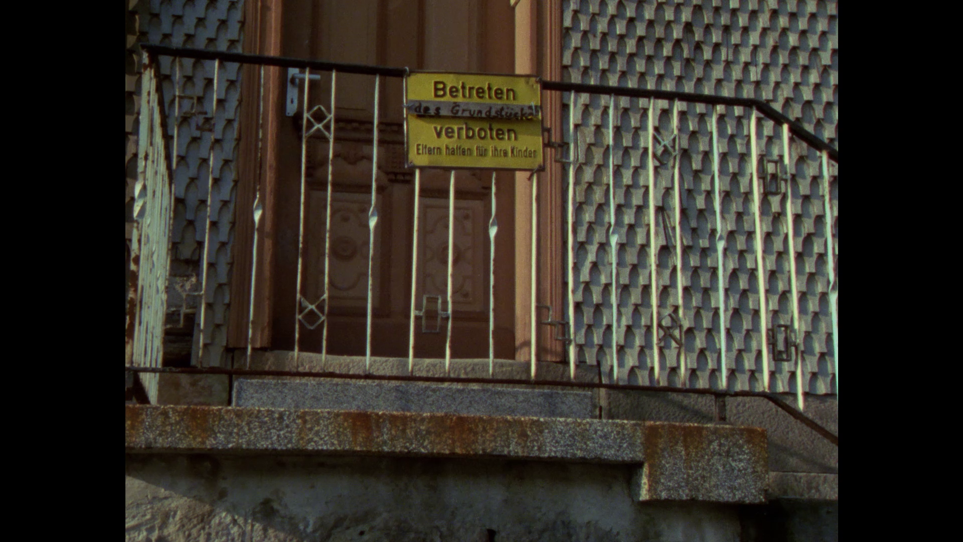 a sign reading "verboten" on a railing